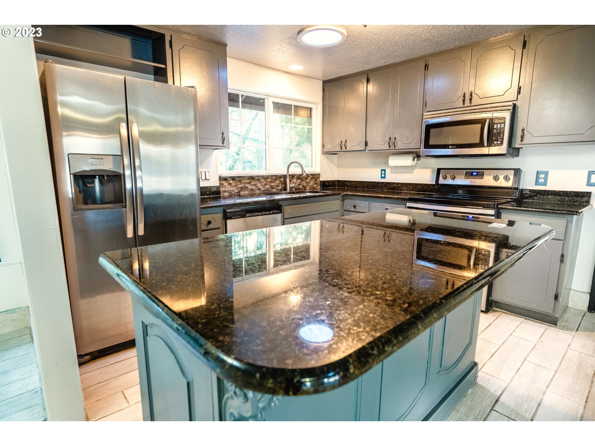 4146 Normandy Way Eugene, OR 97405 - Photo 22 of 48 a kitchen with kitchen island granite countertop a sink counter space appliances and cabinets