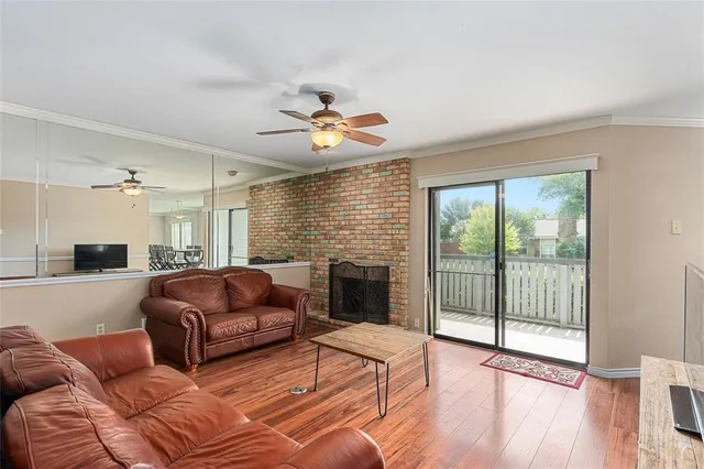 a living room with furniture a fireplace and a floor to ceiling window