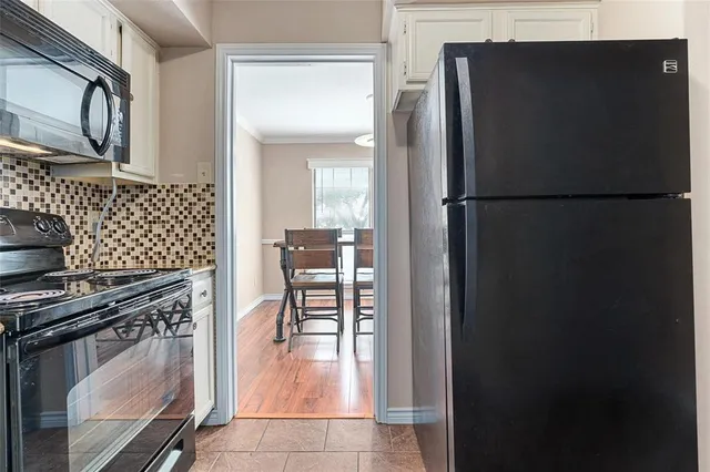 a kitchen with a refrigerator and a stove top oven