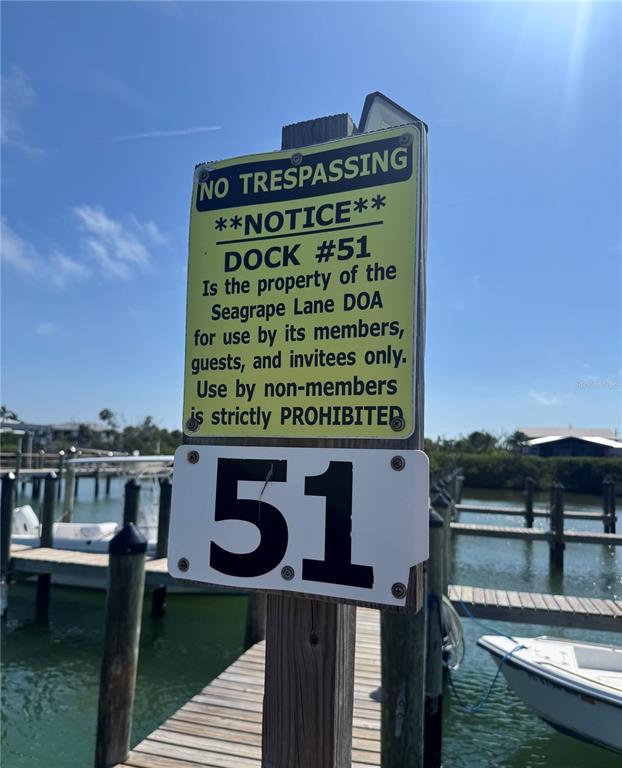 8992 Seagrape Lane Boca Grande, FL 33921 - Photo 3 of 28 a sign on a wall next to a lake