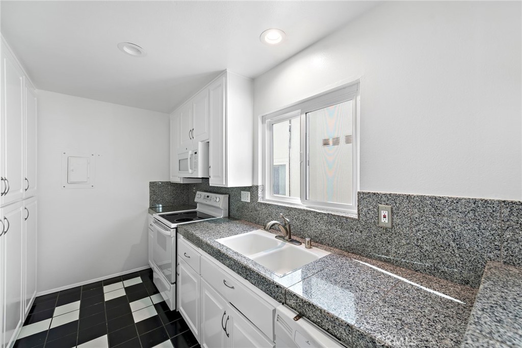 1707 West Balboa Boulevard, Unit A Newport Beach, CA 92663 - Photo 12 of 30 a bathroom with a granite countertop sink and a mirror