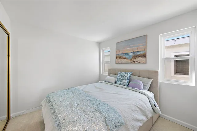 a bedroom with two beds and a painting on the wall