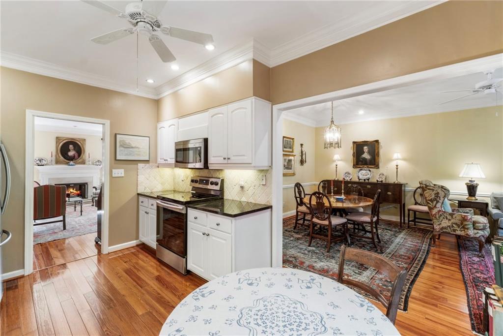 3127 Vinings Ridge Drive Southeast Atlanta, GA 30339 - Photo 6 of 33 a kitchen with stainless steel appliances kitchen island granite countertop a stove top oven a sink a dining table and chairs with wooden floor