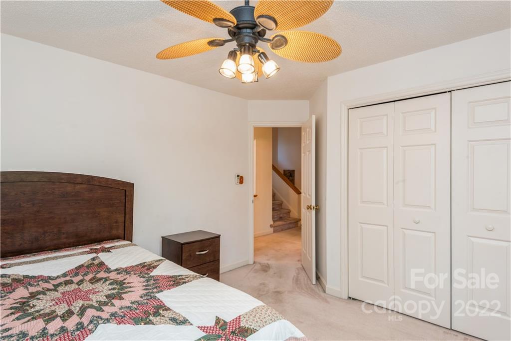 26050 Neptunes Landing Tega Cay, SC 29708 - Photo 28 of 39 a bedroom with a bed and a chandelier