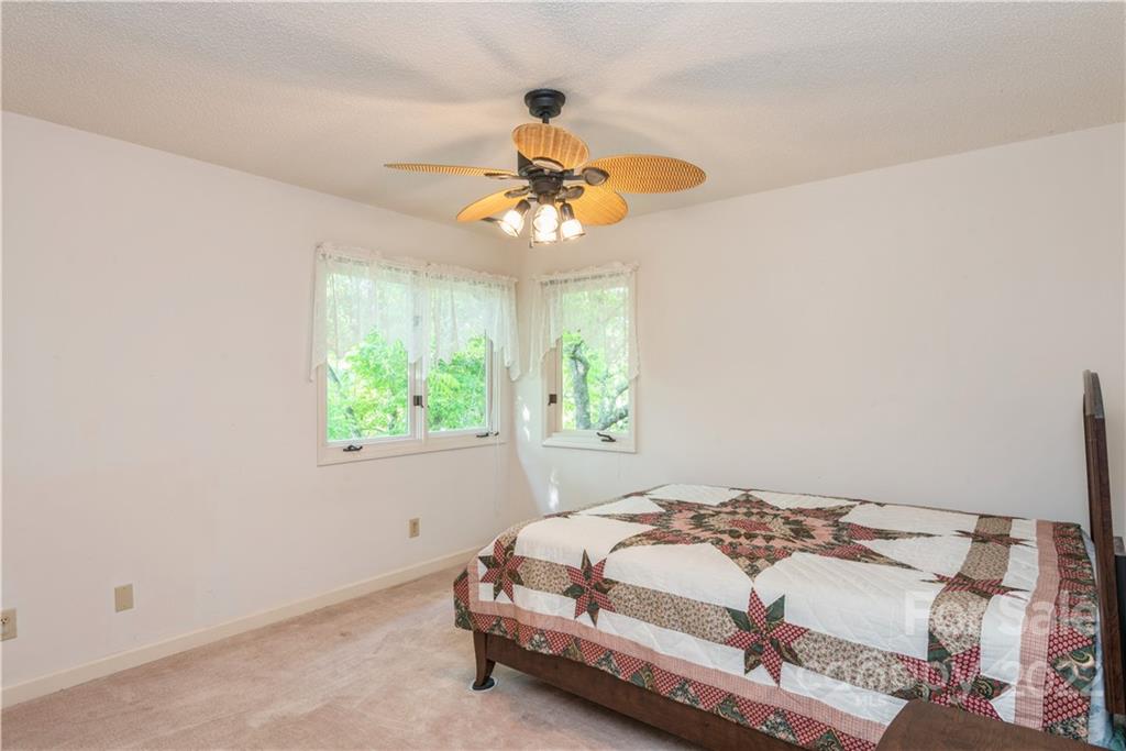 26050 Neptunes Landing Tega Cay, SC 29708 - Photo 29 of 39 a bedroom with a bed and a chandelier
