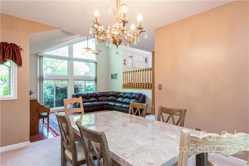 26050 Neptunes Landing Tega Cay, SC 29708 - Photo 8 of 39 a dining room with furniture a large window and wooden floor