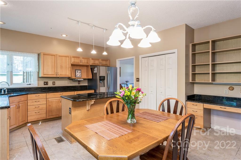 26050 Neptunes Landing Tega Cay, SC 29708 - Photo 10 of 39 a kitchen with stainless steel appliances granite countertop a dining table chairs and granite counter tops