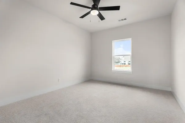 an empty room with a window and a fan