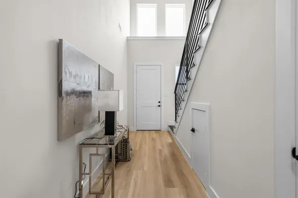 a view of a hallway with wooden floor and staircase