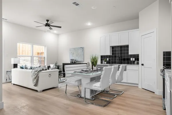 a living room with furniture a flat screen tv and a wooden floor