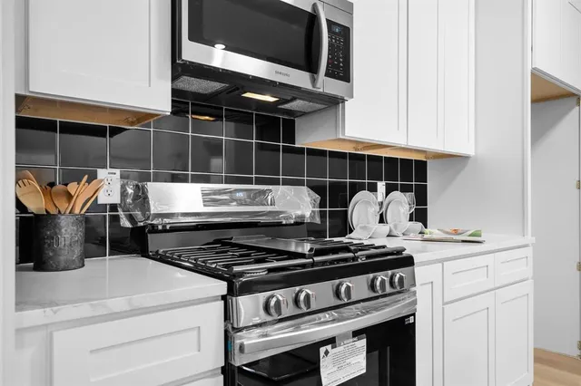 a stove top oven sitting inside of a kitchen