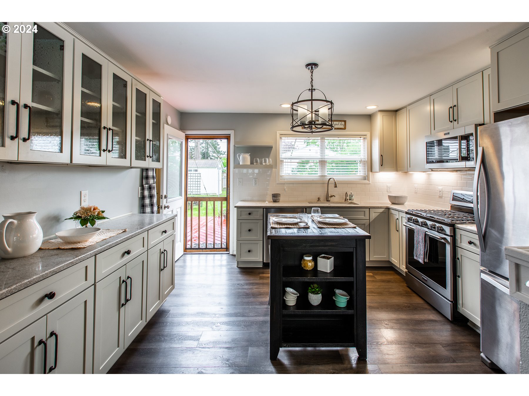 1429 L Street Springfield, OR 97477 - Photo 11 of 20 a kitchen with stainless steel appliances kitchen island granite countertop a stove a sink and a refrigerator