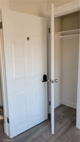 an empty room with wooden floor and window