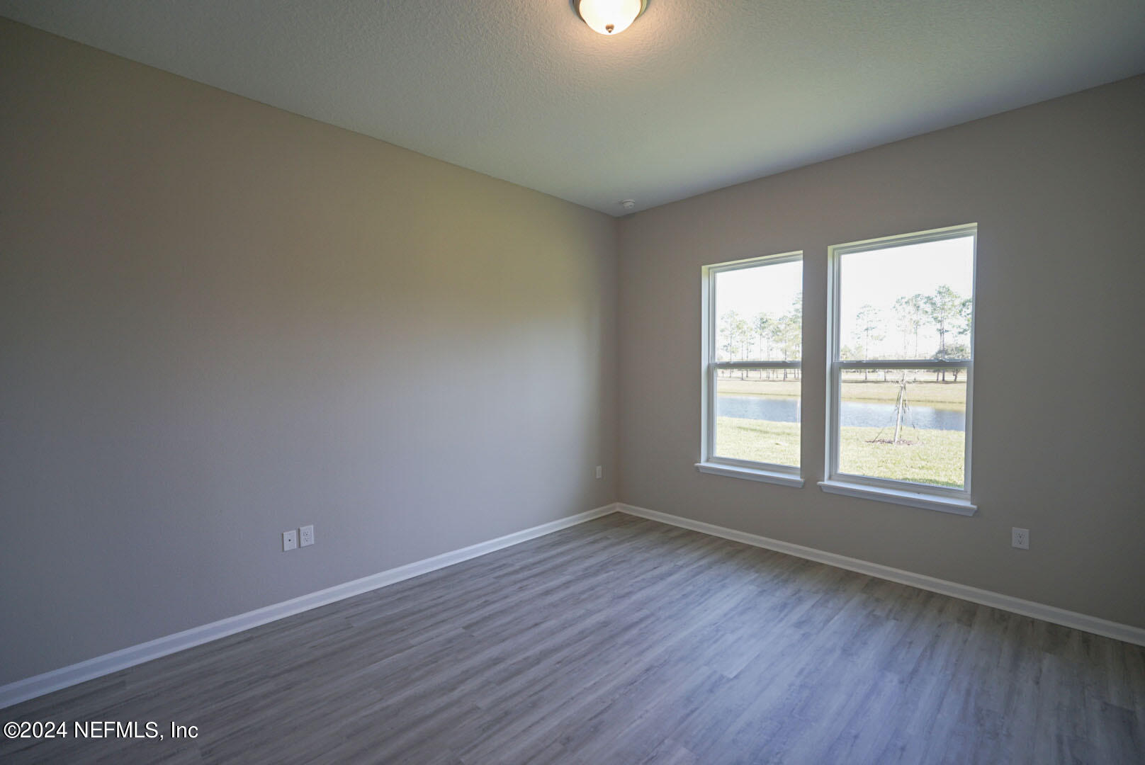 9 Jackson Blue Place Palm Coast, FL 32137 - Photo 10 of 21 an empty room with wooden floor and windows