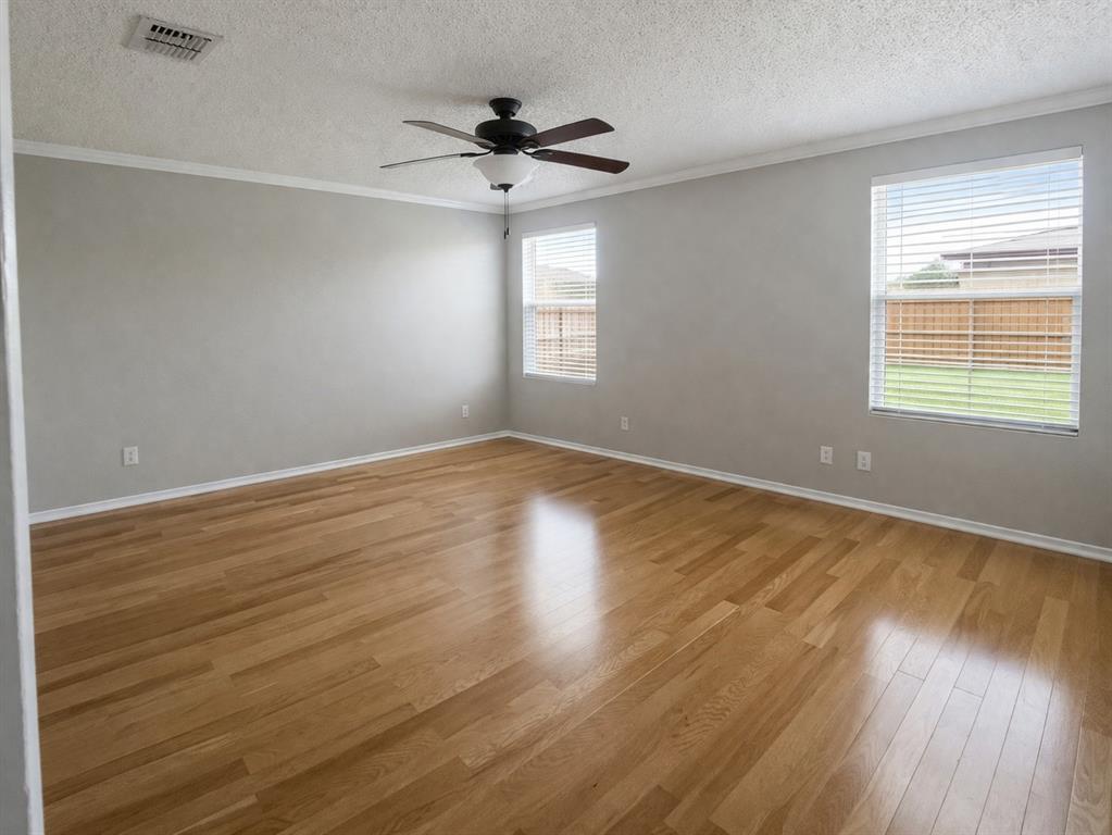1621 Carolina Ridge Way Fort Worth, TX 76247 - Photo 5 of 7 Spare room featuring crown molding, a ceiling fan, light wood finished floors, and a textured ceiling