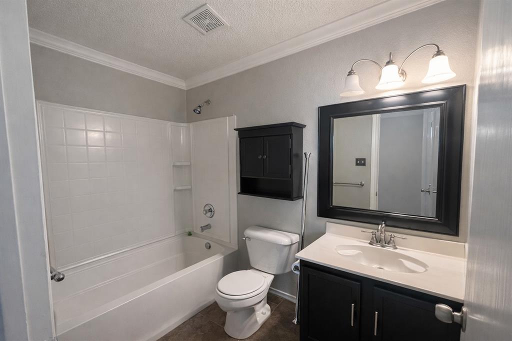 1621 Carolina Ridge Way Fort Worth, TX 76247 - Photo 6 of 7 Full bathroom with vanity, crown molding, bathing tub / shower combination, a textured ceiling, and dark tile patterned flooring