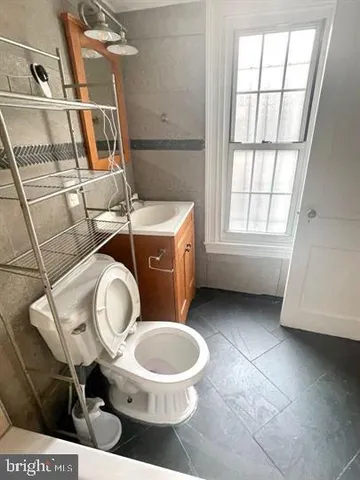 a bathroom with a toilet a sink and a window