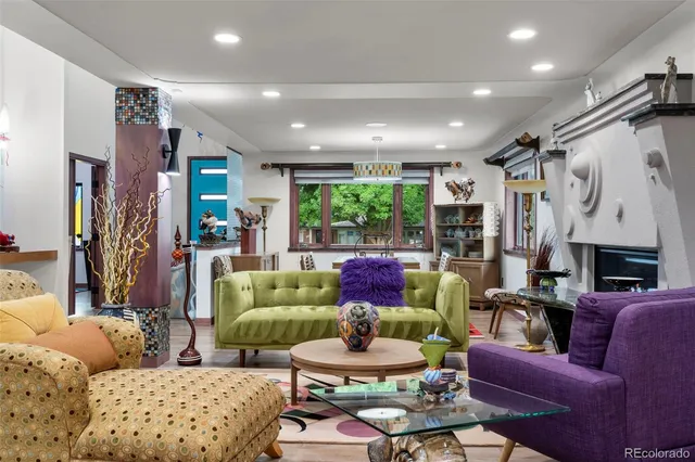 a living room with furniture a fireplace and a large window