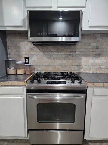 a stove top oven sitting inside of a kitchen