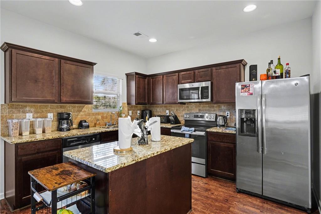 1241 England Terrace Hampton, GA 30228 - Photo 7 of 20 a kitchen with granite countertop stainless steel appliances and wooden cabinets