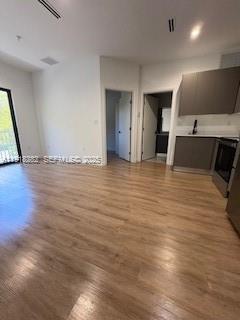 85 Northeast 55th Street, Unit 5 Miami, FL 33137 - Photo 7 of 14 a view of an empty room with wooden floor and a window