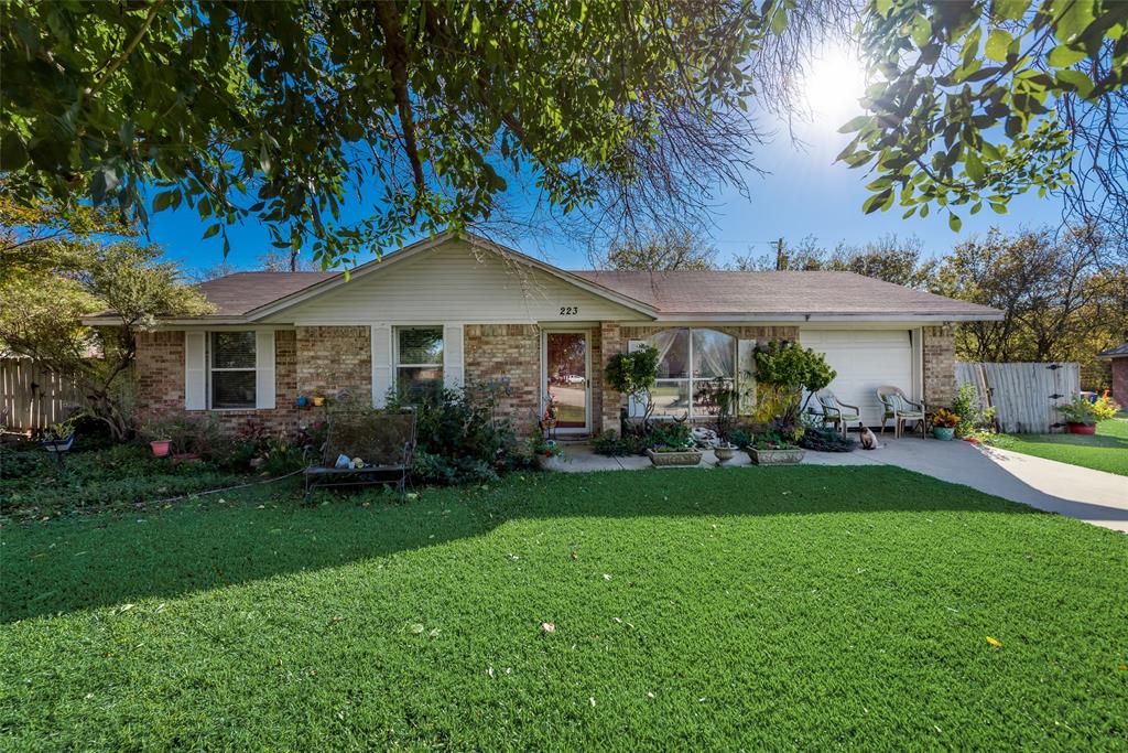 223 Brook Circle Krum, TX 76249 - Photo 1 of 1 a front view of a house with a garden and trees