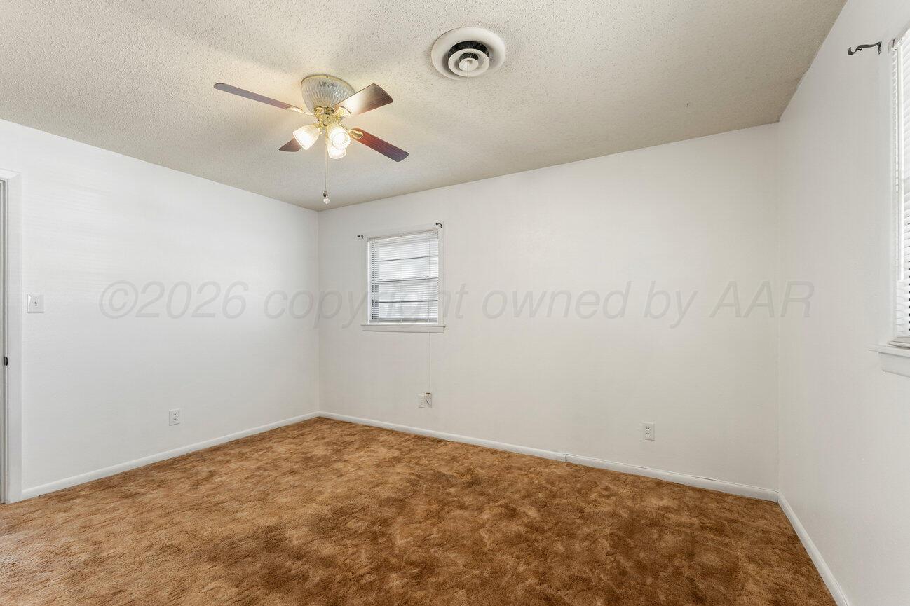 4305 South Bonham Street Amarillo, TX 79110 - Photo 35 of 48 an empty room with a chandelier fan and windows