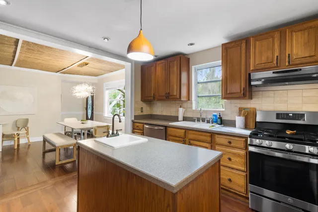 a kitchen with stainless steel appliances a stove a sink a microwave and cabinets