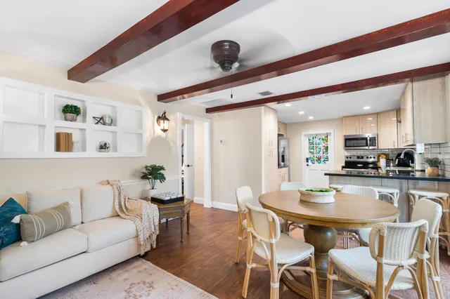 a dining room with furniture potted plants and wooden floor