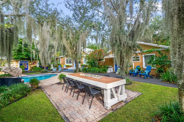 a view of a house with backyard and sitting area