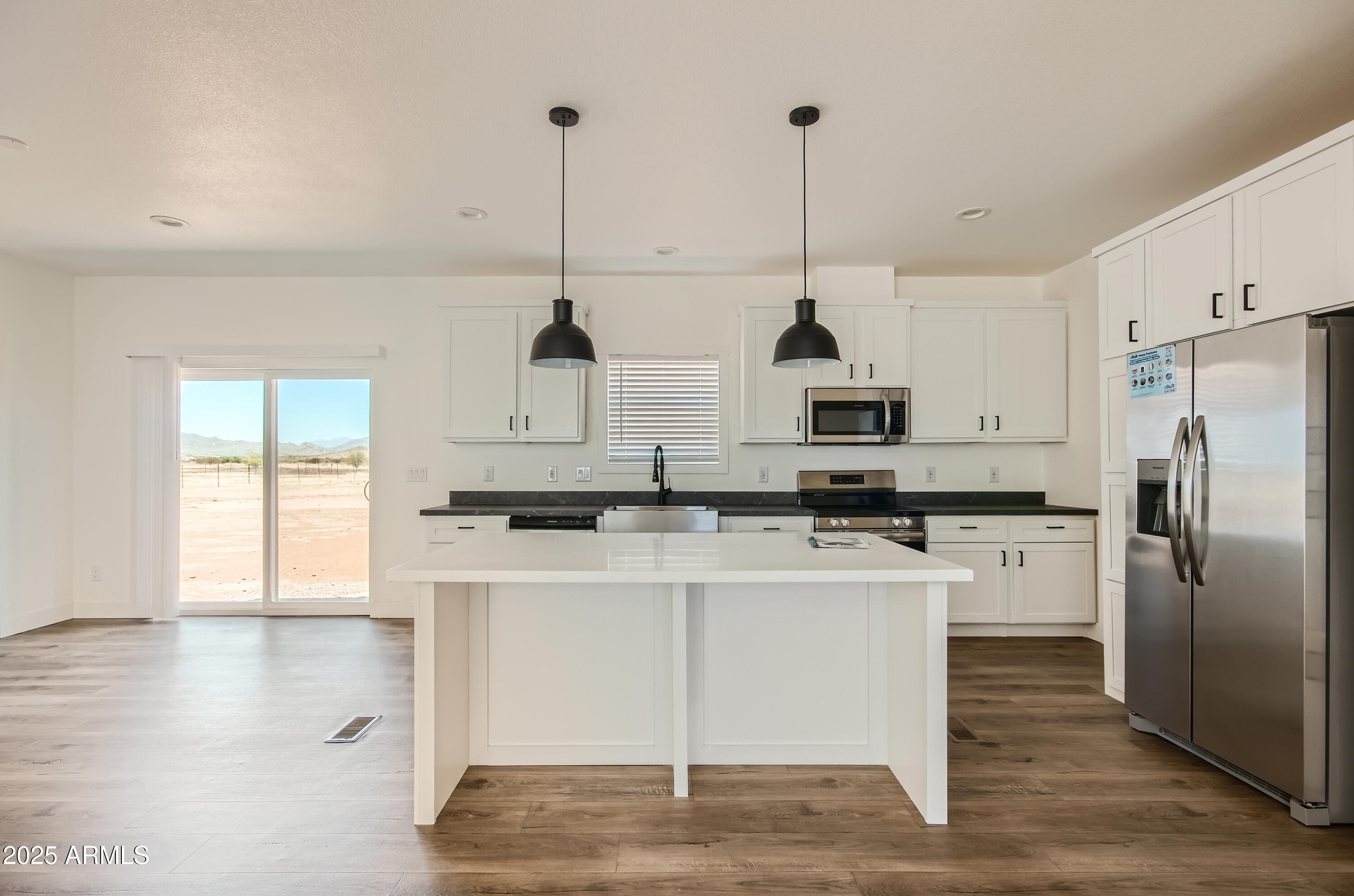 0 North Hidden Valley Road, Unit B Maricopa, AZ 85139 - Photo 2 of 4 a kitchen with stainless steel appliances granite countertop a sink a refrigerator a stove a microwave and wooden floor