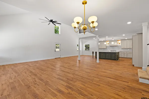 a large kitchen with stainless steel appliances granite countertop a large counter top a stove and a wooden floors