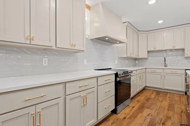 a large white kitchen with a large window