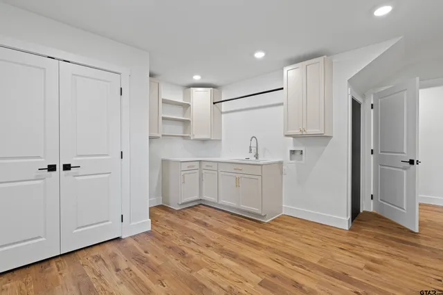 a view of empty room with wooden floor and ceiling fan