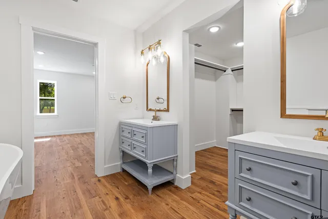 a bathroom with a tub sink and mirror