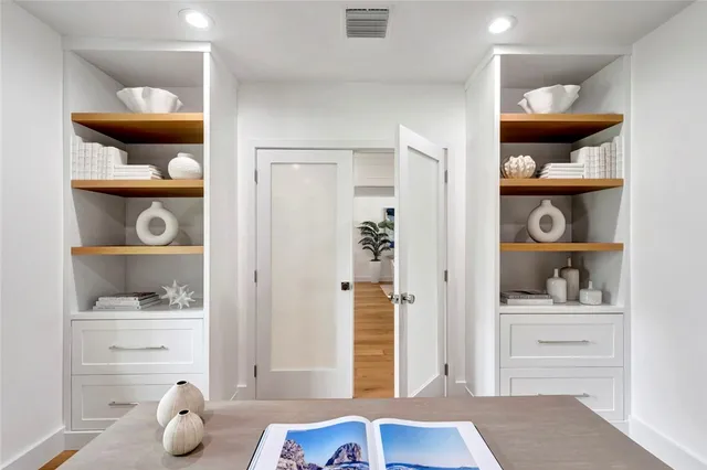 a room with white cabinets and wooden floor