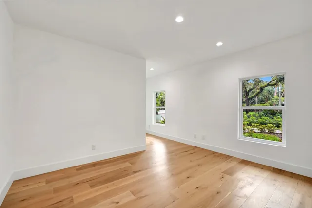 an empty room with wooden floor and window