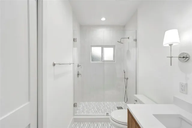 a bathroom with a sink a toilet and shower