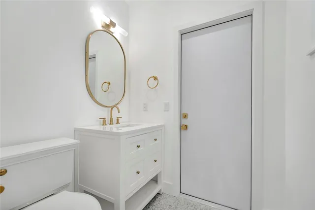 a bathroom with a sink a toilet and a mirror