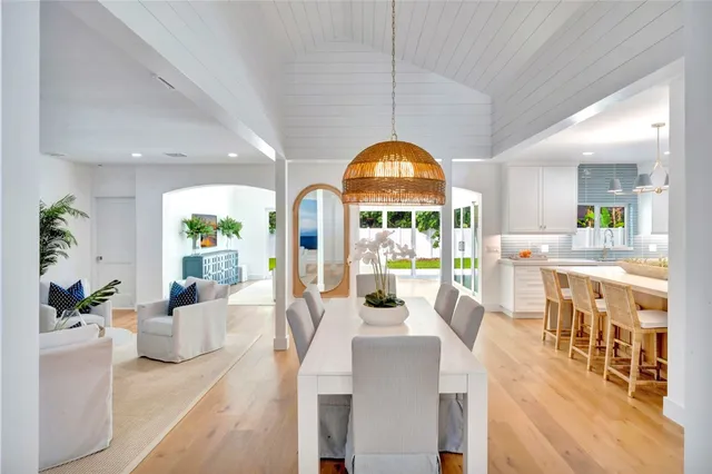 a view of a dining room and livingroom with furniture wooden floor a chandelier