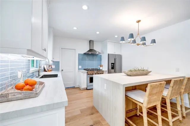 a kitchen with stainless steel appliances kitchen island granite countertop a stove a sink and a refrigerator