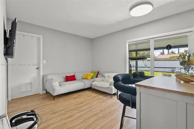 a dining room with stainless steel appliances furniture a window and kitchen view