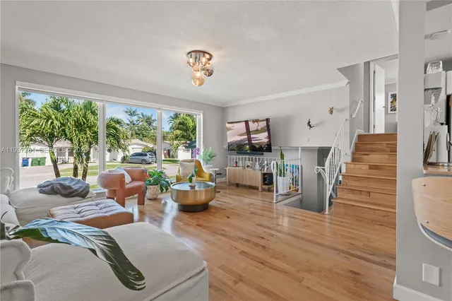 a living room with hard wood floor and a chandelier