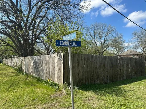 a view of a street sign under a large tree