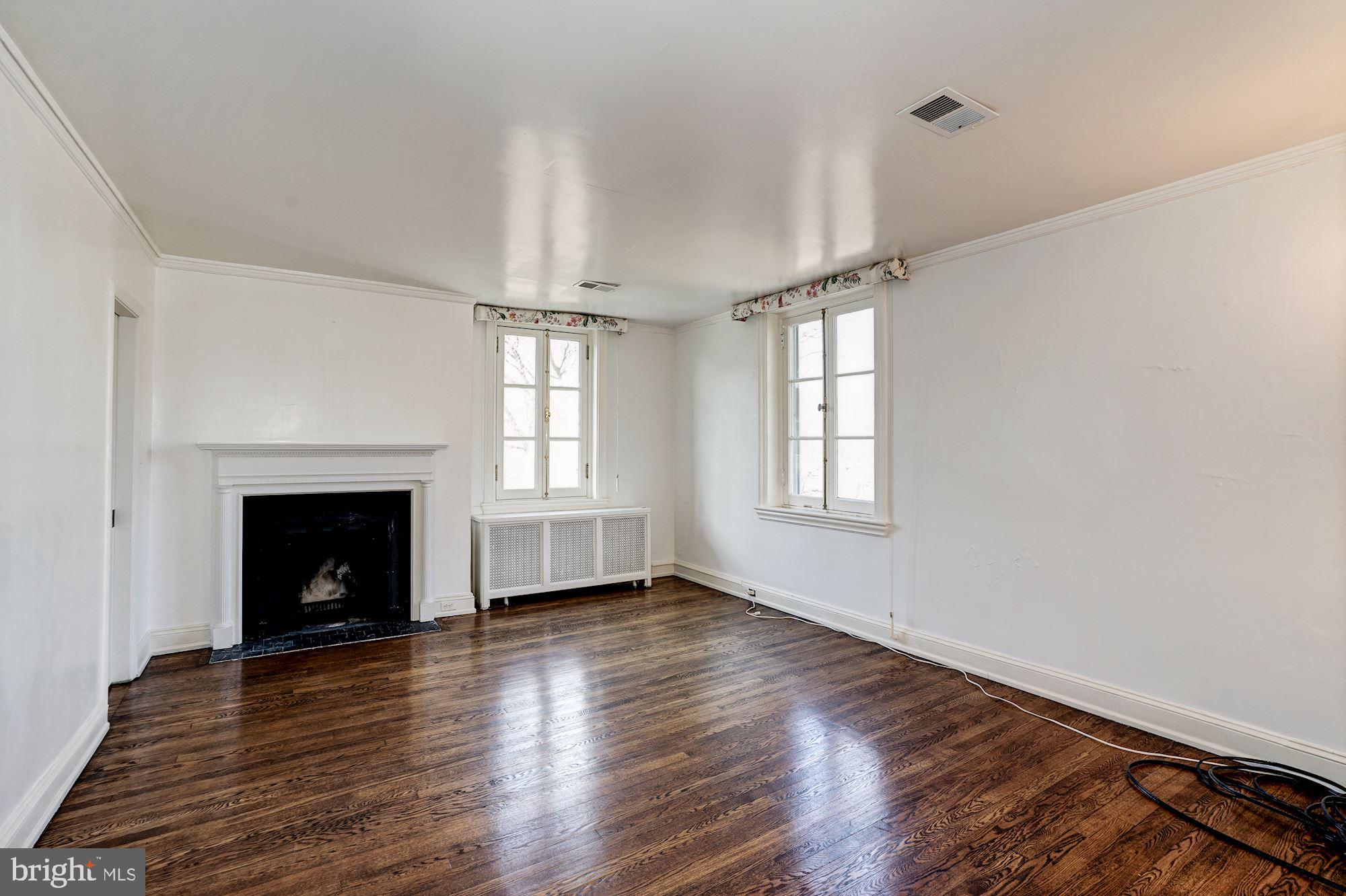 84 Kalorama Circle Northwest Washington, DC 20008 - Photo 38 of 45 an empty room with wooden floor fireplace and windows