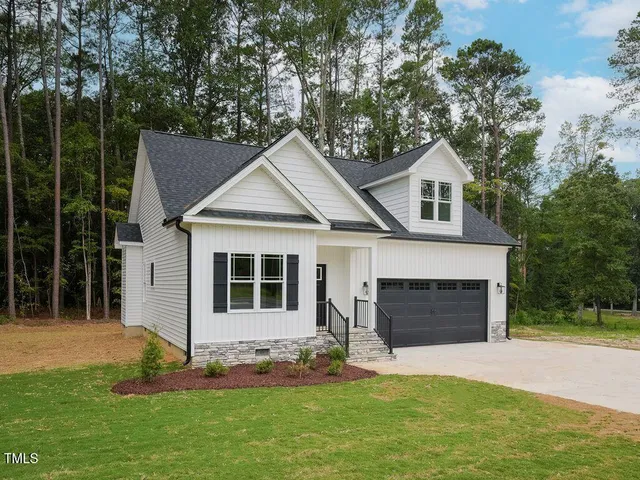 a front view of a house with a garden and yard