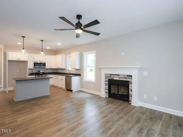 a view of kitchen with kitchen island wooden floor center island and stainless steel appliances