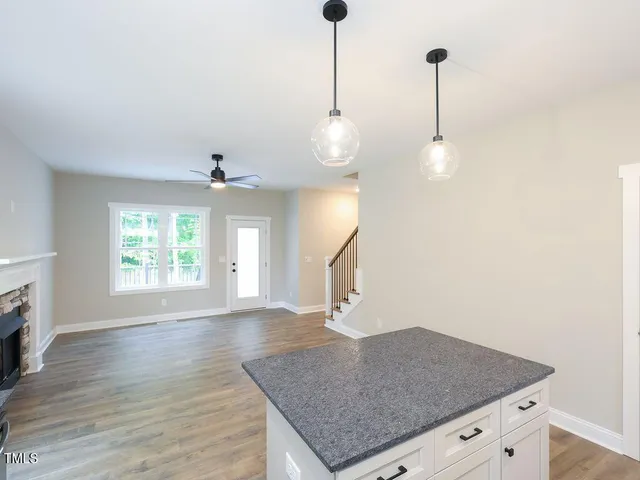 a kitchen with a sink a chandelier and wooden floor