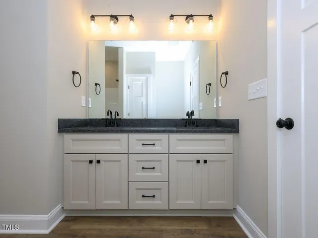 a bathroom with a granite countertop sink and a mirror