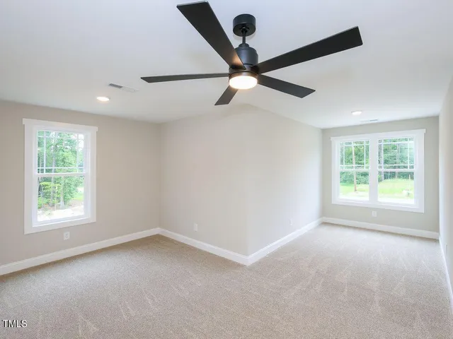 an empty room with a window and a fan